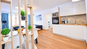 A modern apartment with a kitchen, dining area, and living room. - Sunshine Apartment - Cismigiu Gardens (Bucharest)
