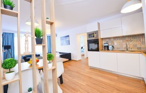 A modern apartment with a kitchen, dining area, and living room.