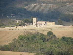 A rural building with a tower, surrounded by fields and trees. - Podere Caldaruccio La Pineta - 26 People Cottage e Villa (Perugia)