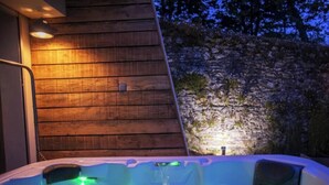 A wooden exterior wall with a hot tub in the foreground. - Gîte Cosy et Calme, Avec spa et Jardin, au Cœur de Morlaix (Morlaix)