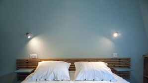 A bedroom with a wooden headboard, two bedside tables, and a bed with white bedding. - Gîte Cosy et Calme, Avec spa et Jardin, au Cœur de Morlaix (Morlaix)