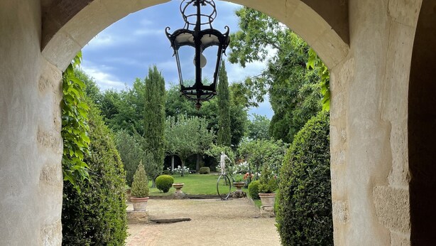 An arched stone pathway leading to a garden with a hanging lantern. - Charming suite, sleeps 4, in a quiet garden in Anjou  (Durtal)