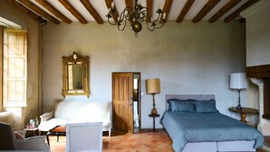 A bedroom with a bed, a chair, a lamp, a mirror, and a chandelier. - Charming suite, sleeps 4, in a quiet garden in Anjou  (Durtal)