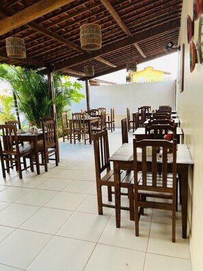 Enjoy a casual dining experience under a covered roof with comfortable seating and ambient lighting.