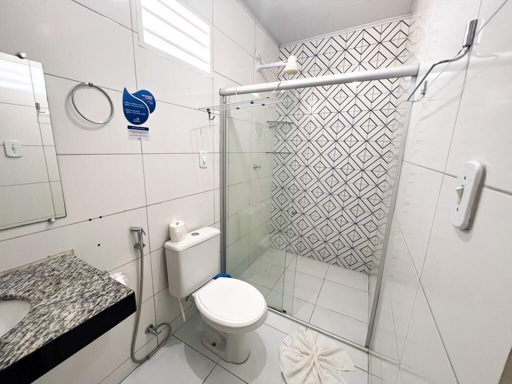 Une salle de bain dotée d’une douche à paroi de verre, de toilettes et d’un lavabo avec un plan de travail en granit.