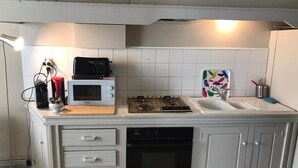 A kitchen with a microwave, stove, sink, and dishwasher. - EGLANTINE  (Dinan)