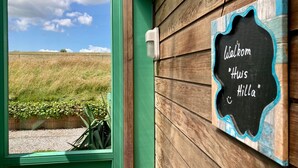 A wooden wall with a chalkboard sign reading "Welkom Huis Hilla". - Holiday Home With Winter Garden by the Lauwersmeer for 4 Guest (Anjum)