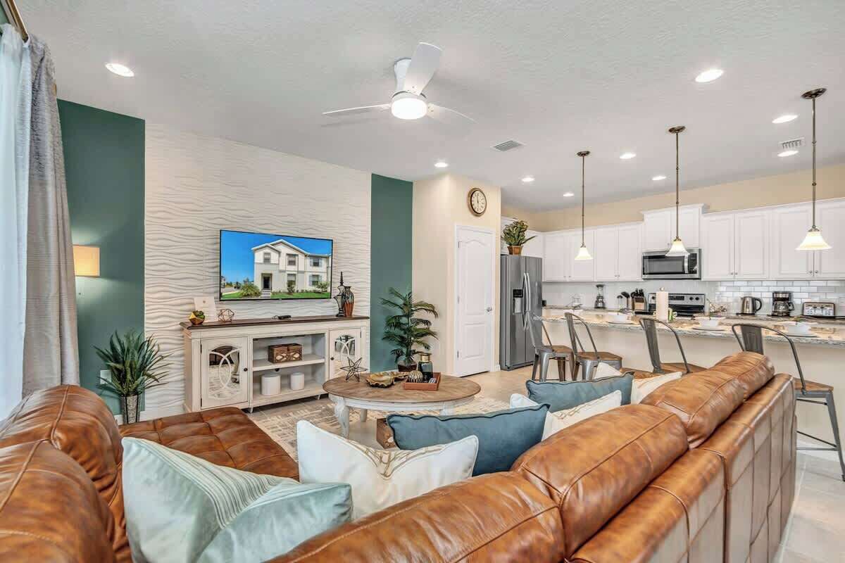 Un salon moderne avec un canapé en cuir, une table basse et un téléviseur.
