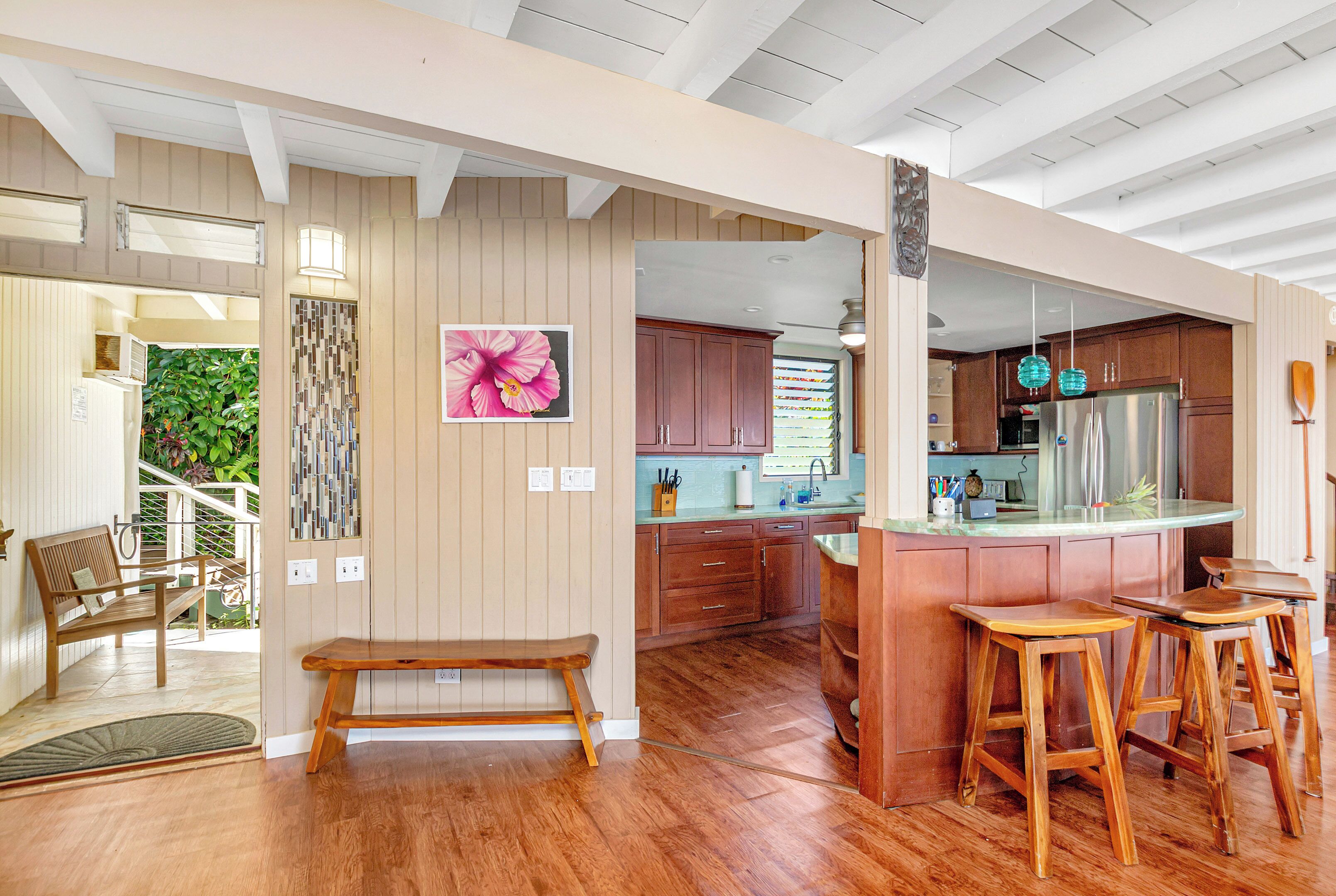 Une cuisine moderne avec des meubles en bois, un îlot central et des tabourets de bar.