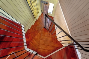 A spiral staircase with a wooden finish and metal railings.