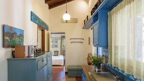 A narrow kitchen with a sink, a wooden cabinet, and a blue wall. - Dine on the Generous Veranda at a Rustic Stone Getaway (Platanias)