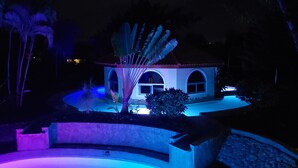A house with a pool, surrounded by palm trees and a stone wall. - Villa 6 Bedrooms Guests Friendly (Sosúa)