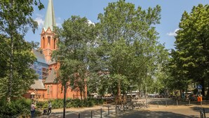 Eine Kirche mit einem hohen Turm und einem Gebäude aus roten Ziegeln.
