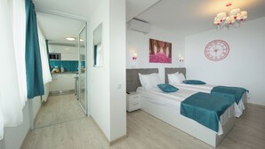 Een moderne slaapkamer met een groot bed, een nachtkastje, een wandklok en een raam met gordijnen.