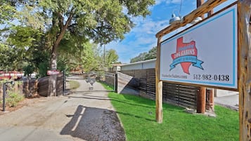 A sign for Wimberley Togg Cabins Resort Suites with a contact number and website.