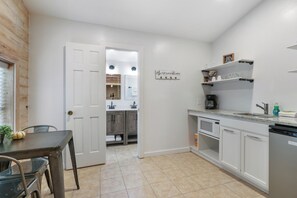 A kitchen with white cabinets, a countertop, a sink, and a coffee maker. - Resort Suite Across the Street from Market Days - Sleeps 4! (Wimberley)