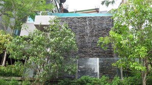 Ein modernes Gebäude mit einer einzigartigen Steinaußenfassade und einem Wasserspiel.
