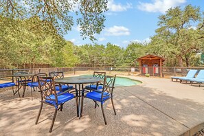 Un espace extérieur aménagé avec des tables et des chaises, une petite piscine et une structure en bois.