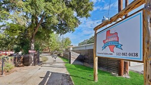 Señal para Wimberley Togg Cabins Resort Suites, con un número de contacto y sitio web.