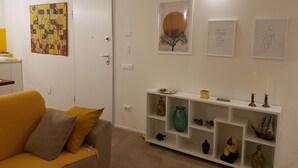 Ein Wohnzimmer mit einer Couch, einer weißen Tür und einem Regal mit Dekoration.