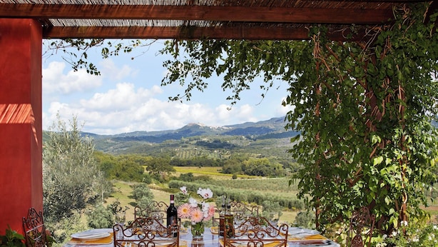 An outdoor dining area with a table set for four, overlooking a scenic landscape with mountains and vineyards. - Holiday Home With Exclusive Swimming Pool in the Tuscan Maremma (Roccastrada)