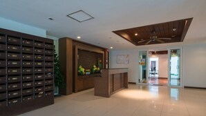 A modern hotel lobby with a reception desk, a plant, and a wall of numbered storage boxes. - 639 2 Bedroom Contemporary Teak Wood Patong Beach (Patong)