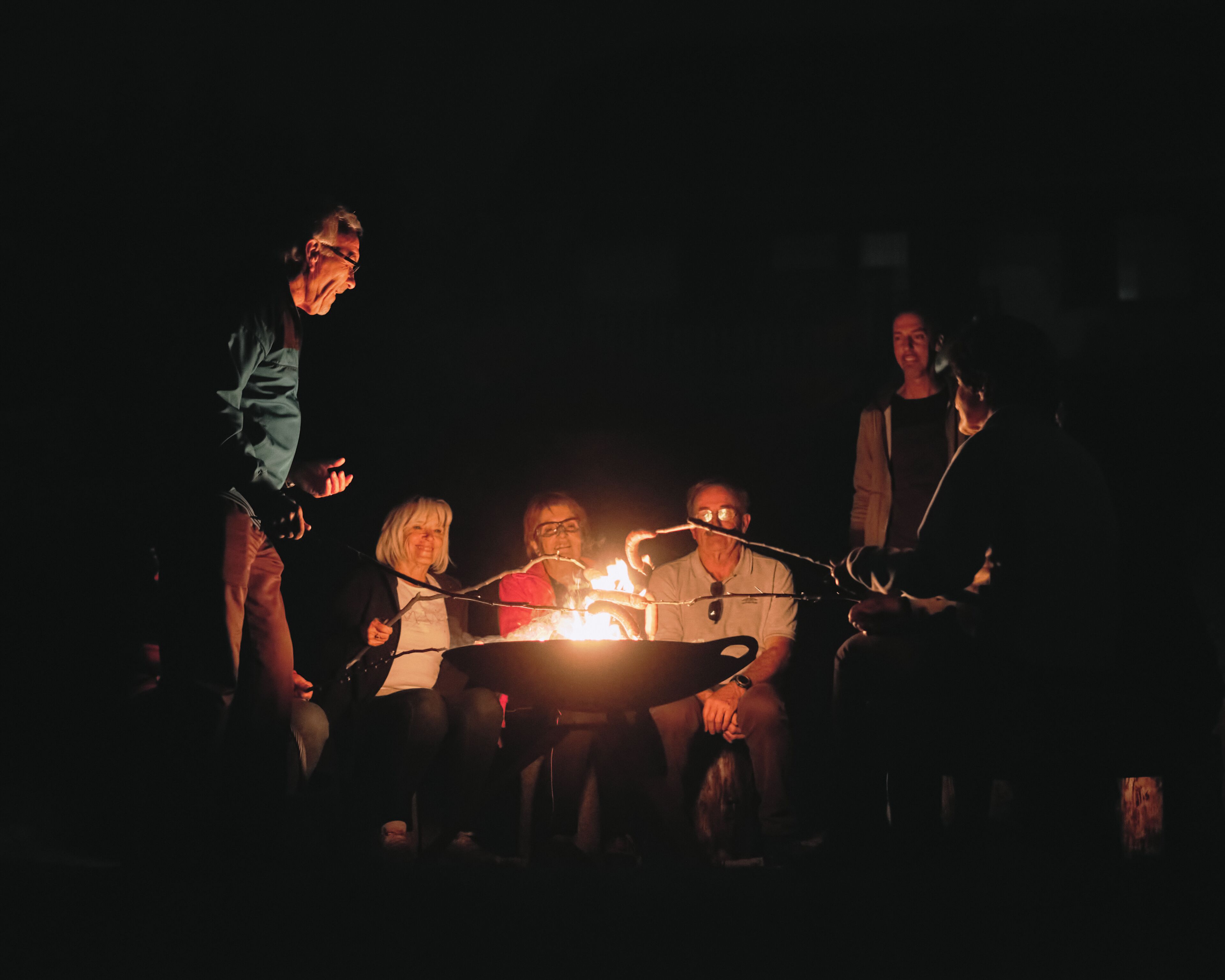 A group of people gathered around a campfire at night.