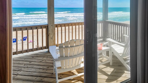 A wooden deck with chairs and a table, overlooking a beach with waves. - ON THE BEACH! Spiritual Sunrises and Glorious Sunsets, dogs welcome! (Rodanthe)