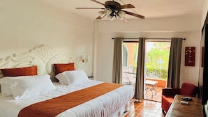 A hotel room with a large bed, a ceiling fan, a TV, and a view of the outdoors. - Sunny Apartment In The Heart of the Exclusive Marina Vallarta (Puerto Vallarta)