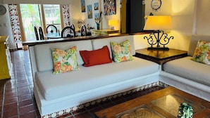 A living room with a sofa, a coffee table, and a dining area with chairs and a table. - Sunny Apartment In The Heart of the Exclusive Marina Vallarta (Puerto Vallarta)