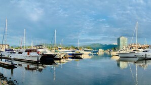 A marina with multiple boats docked, a clear sky, and a distant mountain range. - Sunny Apartment In The Heart of the Exclusive Marina Vallarta (Puerto Vallarta)