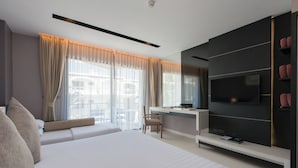 Een moderne hotelkamer met een groot bed, een bureau en een televisie.