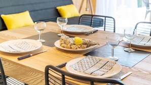 A dining table set with plates, cutlery, and glasses, with a bowl of food and a lemon wedge on a plate. - Résidence Ker Eden by Interhome (Quiberon)