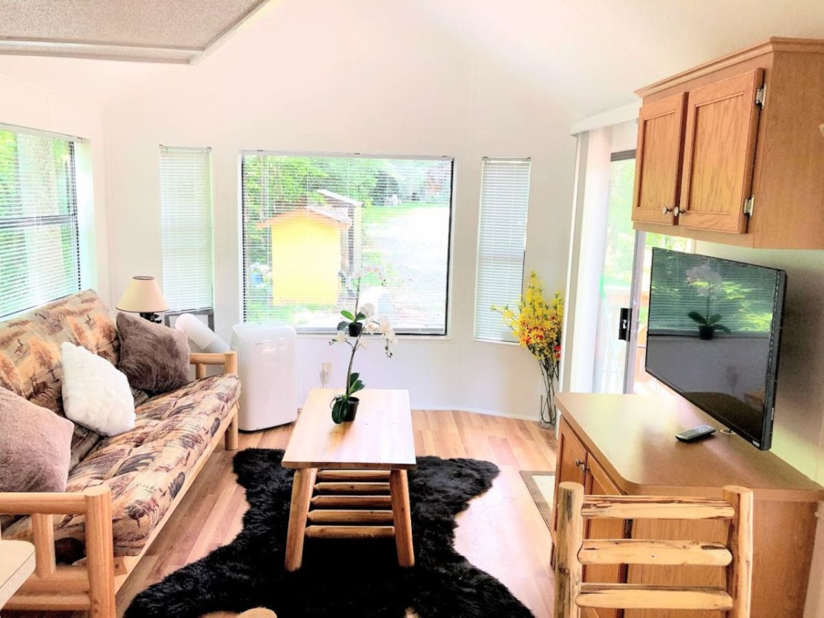 A modern living room with a sofa, a coffee table, a TV, and wooden cabinets.