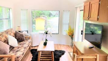A modern living room with a sofa, a coffee table, a TV, and wooden cabinets.