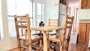 A wooden dining table with four chairs in a kitchen with wooden flooring and white walls. - 4 Cabins/Mountain Views /Jacuzzi/Wi-Fi/Large Groups (Whittier)