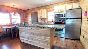 A kitchen with wooden cabinets, a stainless steel refrigerator, a microwave, and an oven. - 4 Cabins/Mountain Views /Jacuzzi/Wi-Fi/Large Groups (Whittier)