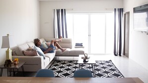 A modern living room with a sofa, a coffee table, and a patterned rug. - Beautiful Condo 300 Meters To Medano Beach (Cabo San Lucas)