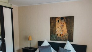 A bedroom with a bed, a nightstand, a lamp, and a painting on the wall. - Holiday Home 'Haus Piratennest' with Private Terrace, Garden & Wi-Fi (Grömitz)