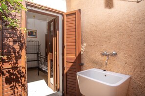 Ein Badezimmer mit Waschbecken, einer Holztür und einem Metallgeländer.