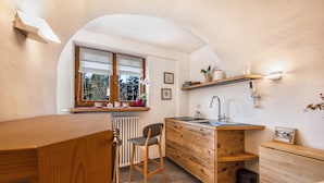 A compact kitchen with a wooden countertop, a sink, and a window with a view of greenery. - Apartment "Mariagrazia" with Mountain Views and Garden (Tesero)