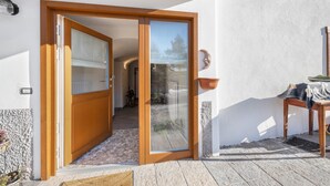 A wooden door leading to a room with a tiled floor and a potted plant. - Apartment "Mariagrazia" with Mountain Views and Garden (Tesero)