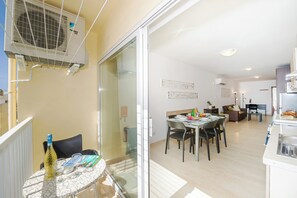 Eine moderne Wohnung mit Essbereich, Küche und einem Balkon mit Klimaanlage.