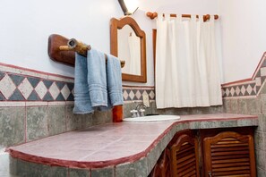 A bathroom with a sink, mirror, and wooden cabinets.