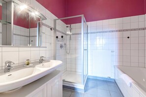 Un baño con dos lavamanos, ducha y bañera.