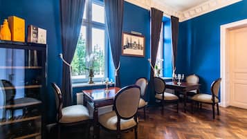 A dining area with a table, chairs, and a window with curtains.
