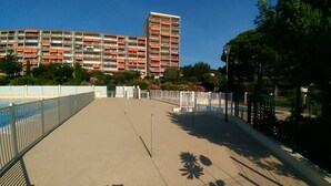 Ein Poolbereich auf dem Dach mit Blick auf ein mehrstöckiges Gebäude im Hintergrund.