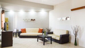 Een moderne woonkamer met een bank, salontafel en decoratieve objecten.