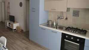 A modern kitchen with blue cabinets, a gas stove, and a built-in oven. - SeaHouse (Torre Vado marina di morciano di leuca)