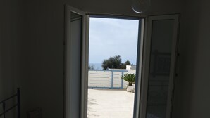 A bedroom with a bed, a window, and a view of the outside. - SeaHouse (Torre Vado marina di morciano di leuca)